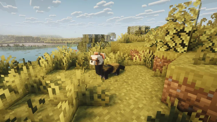 A red panda-like creature in tall grass beside a lake, with dark woven structures and pink terracotta nearby.